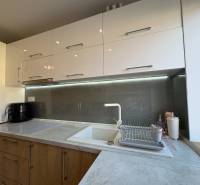 NA PREDAJ vkusne zrekonštruovaný  2 izbový byt, Komárno - Kuchyňa v 2-izbovom byte so svetlými skrinkami a podsvietením nad pracovnou doskou.