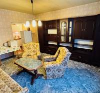 Na predaj 2 i byt v Partizánskom - Šípok - Obývacia izba v 2-izbovom byte so starším nábytkom a kobercom na podlahe.