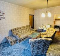 Na predaj 2 i byt v Partizánskom - Šípok - Obývacia izba s retro sedacou súpravou, vzorovaný koberec, vstup do kuchyne v 2-izbovom byte.