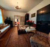 Na predaj rodinný dom v širšom centre mesta Komárno. - Obývacia izba v rodinnom dome s pohovkami, TV a podlahou s dreveným dekorom.