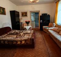 Na predaj rodinný dom v širšom centre mesta Komárno. - Obývacia izba v rodinnom dome s kvetmi, pohovkou a podlahou s dreveným dekorom.