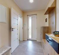 4-izbový dom 132m2 + pozemok 484m2 | Bernolákovo - Vstupná hala rodinného domu s dlažbou, dekoratívnymi obrazmi a odkladacím priestorom.