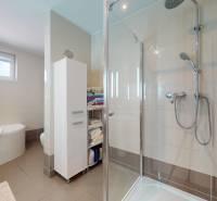 4-izbový dom 132m2 + pozemok 484m2 | Bernolákovo - Kúpeľňa v rodinnom dome s vaňou, sprchovacím kútom a skladovacími policami.