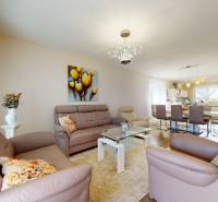 4-izbový dom 132m2 + pozemok 484m2 | Bernolákovo - Obývacia izba v rodinnom dome s koženými sedačkami a skleneným stolíkom.