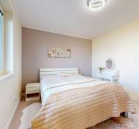 4-izbový dom 132m2 + pozemok 484m2 | Bernolákovo - Svetlá spálňa v rodinnom dome s posteľou a stolíkom.