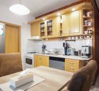 3-izbový byt s loggiou na ul. S.H. Vajanského, Nové Zámky – 74,69m2 - Kuchyňa v 3-izbovom byte so svetlou kuchynskou linkou, spotrebičmi a stolom so stoličkami.