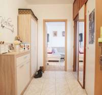 3-izbový byt s loggiou na ul. S.H. Vajanského, Nové Zámky – 74,69m2 - Chodba v 3-izbovom byte s dlažbou a útulným nábytkom v drevenom dekore.