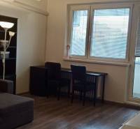 Prenájom 2-izbový byt na začiatku Petržalky - Obývacia izba v 2-izbovom byte s rohovou sedačkou a podlahou s dreveným dekorom.