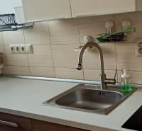 Prenájom 2-izbový byt na začiatku Petržalky - Kuchyňa v 2-izbovom byte s umývadlom, sklokeramickou varnou doskou a košíkom pri okne.