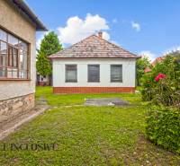 NA PREDAJ 2 ROD. DOMY NA 12-ÁROVOM POZEMKU, MALÁ MAČA - Záhrada rodinného domu v Malej Mači pri Galante so zeleným trávnikom a kvetmi.