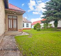 NA PREDAJ 2 ROD. DOMY NA 12-ÁROVOM POZEMKU, MALÁ MAČA - Rodinný dom na Malej Mači v Galante s červenou strechou a zelenou záhradou.