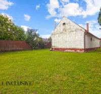 NA PREDAJ 2 ROD. DOMY NA 12-ÁROVOM POZEMKU, MALÁ MAČA - Rodinný dom na ulici Malá Mača v Galante s priestranným trávnikom a stromami.