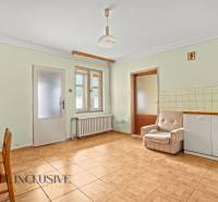 NA PREDAJ 3-IZBOVÝ RODINNÝ DOM, PUSTÉ ÚĽANY - Obývacia izba v rodinnom dome s podlahou s dreveným dekorom a jednoduchým nábytkom.