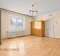 NA PREDAJ 3-IZBOVÝ RODINNÝ DOM, PUSTÉ ÚĽANY - Interiér rodinného domu s podlahou s dreveným dekorom, skriňou a lustrom.