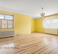 NA PREDAJ 3-IZBOVÝ RODINNÝ DOM, PUSTÉ ÚĽANY - Obývacia izba s podlahou s dreveným dekorom, žltými stenami a lustrom v rodinnom dome.