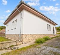 NA PREDAJ 5-IZBOVÝ RODINNÝ DOM NA 15Á POZEMKU,ŠALGOČKA - Rodinný dom v Šalgočke s bielou fasádou, okolitou zeleňou a betónovou prístupovou cestou.