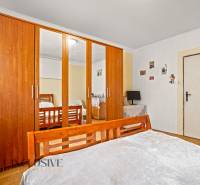 NA PREDAJ 5-IZBOVÝ RODINNÝ DOM NA 15Á POZEMKU,ŠALGOČKA - Spálňa v rodinnom dome s drevenou skriňou a zrkadlom, podlaha s dreveným dekorom.