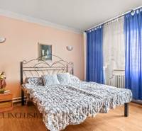 NA PREDAJ 5-IZBOVÝ RODINNÝ DOM NA 15Á POZEMKU,ŠALGOČKA - Spálňa v rodinnom dome s kovovou posteľou, modrými závesmi a podlahou s dreveným dekorom.