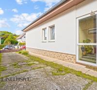 NA PREDAJ 5-IZBOVÝ RODINNÝ DOM NA 15Á POZEMKU,ŠALGOČKA - Rodinný dom v Šalgočke s betónovým chodníkom, bielou fasádou a sklenými dverami.