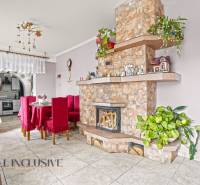 NA PREDAJ 5-IZBOVÝ RODINNÝ DOM NA 15Á POZEMKU,ŠALGOČKA - Obývacia izba v rodinnom dome s krbom, jedálenským stolom a dekoráciami.