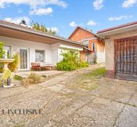 NA PREDAJ 5-IZBOVÝ RODINNÝ DOM NA 15Á POZEMKU,ŠALGOČKA - Dvor rodinného domu v Šalgočke so zeleňou a drevenou garážou.