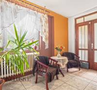 NA PREDAJ 5-IZBOVÝ RODINNÝ DOM NA 15Á POZEMKU,ŠALGOČKA - Interiér rodinného domu s rastlinou, dvoma kreslami a stolíkom s kvetmi.