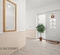 REZERVOVANÉ 5-IZBOVÝ RODINNÝ DOM VO VEĽKEJ PAKE - Chodba v rodinnom dome s bielymi dverami, zrkadlom a izbovou rastlinou.