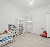 REZERVOVANÉ 5-IZBOVÝ RODINNÝ DOM VO VEĽKEJ PAKE - Detská izba v rodinnom dome s posteľou, hračkami a podlahou s dreveným dekorom.