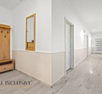 REZERVOVANÉ 5-IZBOVÝ RODINNÝ DOM VO VEĽKEJ PAKE - Chodba v rodinnom dome s bielymi stenami a dreveným dekórom.