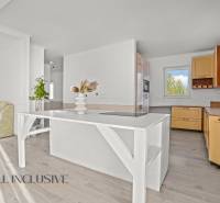 REZERVOVANÉ 5-IZBOVÝ RODINNÝ DOM VO VEĽKEJ PAKE - Kuchyňa v rodinnom dome s podlahou s dreveným dekorom a svetlým nábytkom.