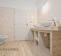 REZERVOVANÉ 5-IZBOVÝ RODINNÝ DOM VO VEĽKEJ PAKE - Kúpeľňa v rodinnom dome s dvoma umývadlami, svetlé obklady, podlaha s dreveným dekorom.