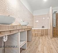 REZERVOVANÉ 5-IZBOVÝ RODINNÝ DOM VO VEĽKEJ PAKE - Kúpeľňa v rodinnom dome s vaňou, sprchovacím kútom a podlahou s dreveným dekorom.