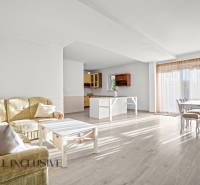 REZERVOVANÉ 5-IZBOVÝ RODINNÝ DOM VO VEĽKEJ PAKE - Obývacia izba s kuchyňou a podlahou s dreveným dekorom v rodinnom dome.