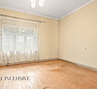 NA PREDAJ 4-IZBOVÝ RODINNÝ DOM V OBCI MOSTOVÁ - Izba rodinného domu s podlahou s dreveným dekorom a závesom na okne.