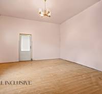 NA PREDAJ 4-IZBOVÝ RODINNÝ DOM V OBCI MOSTOVÁ - Priestranná miestnosť s podlahou s dreveným dekorom a dvomi dverami, rodinný dom.