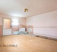 NA PREDAJ 4-IZBOVÝ RODINNÝ DOM V OBCI MOSTOVÁ - Interiér rodinného domu s podlahou s dreveným dekorom a poškodenou stenou.