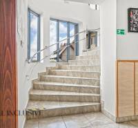 NA PREDAJ ŠKOLSKÁ BUDOVA NA VEĽKOM POZEMKU, MOSTOVÁ - Schodisko s dlaždicovou podlahou v budove, steny so zábradlím a obrazmi.