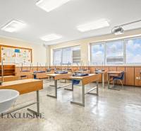 NA PREDAJ ŠKOLSKÁ BUDOVA NA VEĽKOM POZEMKU, MOSTOVÁ - Interiér triedy v budove s oknami, lavicami a stoličkami.