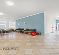 NA PREDAJ ŠKOLSKÁ BUDOVA NA VEĽKOM POZEMKU, MOSTOVÁ - Interiér budovy s podlahou s dreveným dekorom, sedacími súpravami a modrou stenou.