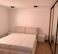 Prenájom: 2 izbový byt v obci Staškov (316-B) - Svetlá spálňa 2-izbového bytu s podlahou s dreveným dekorom a pohodlnou posteľou.