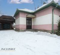 Na predaj 4-izbový rodinný dom, Gabčíkovo - Rodinný dom v Gabčíkove obklopený snehom, vedľa stojí garážový prístrešok.