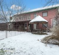 Na predaj 4-izbový rodinný dom, Gabčíkovo - Rodinný dom v Gabčíkove s vonkajším dvorom, stromom a snehovou pokrývkou.