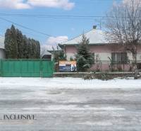 Na predaj 4-izbový rodinný dom, Gabčíkovo - Rodinný dom v Gabčíkove s predajným nápisom a zasneženým okolím.