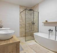 NA PREDAJ 4 IZB RD S DVOJGARÁŽOU, DUNAJSKÁ STREDA - Kúpeľňa v rodinnom dome s vaňou, sprchou a umývadlami na podlahe s dreveným dekorom.