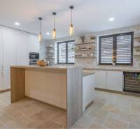 NA PREDAJ 4 IZB RD S DVOJGARÁŽOU, DUNAJSKÁ STREDA - Kuchyňa v rodinnom dome s pultom, policami a dlažbou s dreveným dekorom.