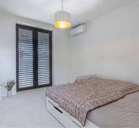 NA PREDAJ 4 IZB RD S DVOJGARÁŽOU, DUNAJSKÁ STREDA - Spálňa v rodinnom dome so zrkadlom, posteľou, klimatizáciou a francúzskym oknom.