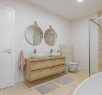 NA PREDAJ 4 IZB RD S DVOJGARÁŽOU, DUNAJSKÁ STREDA - Kúpeľňa s dvoma okrúhlymi zrkadlami a kamenným obkladom v rodinnom dome.