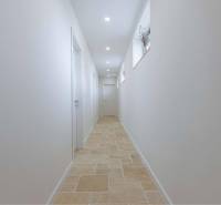 NA PREDAJ 4 IZB RD S DVOJGARÁŽOU, DUNAJSKÁ STREDA - Úzky svetlý chodba s bielymi stenami a kamennou podlahou v rodinnom dome.