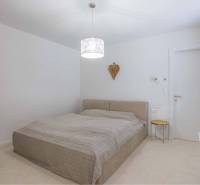 NA PREDAJ 4 IZB RD S DVOJGARÁŽOU, DUNAJSKÁ STREDA - Spálňa s posteľou a nočným stolíkom v rodinnom dome, neutrálne farby interiéru.