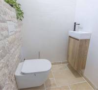 NA PREDAJ 4 IZB RD S DVOJGARÁŽOU, DUNAJSKÁ STREDA - Toaleta s kamennou stenou a malým umývadlom v rodinnom dome.